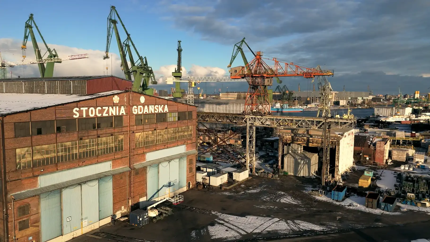 Historic Gdańsk shipyard with monumental cranes and brick industrial buildings