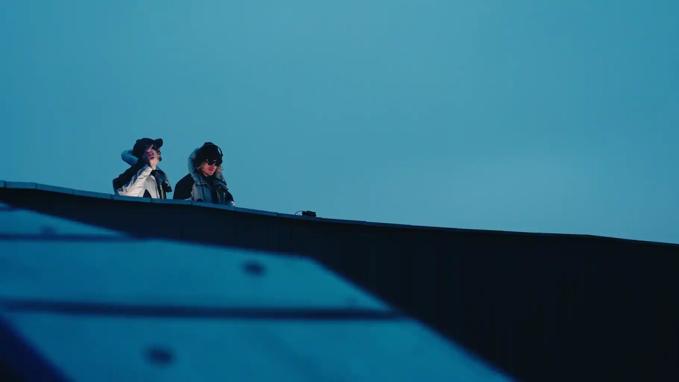 Two DJs performing beneath a wide open blue sky